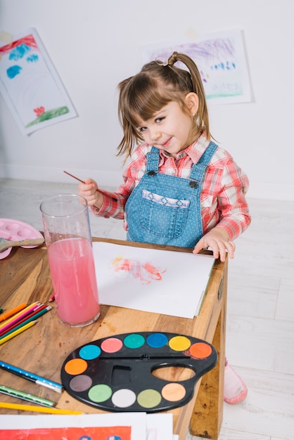 Free photo pretty girl painting with aquarelle on paper