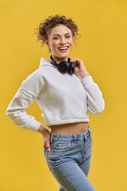 Pretty girl posing with earphones on neck