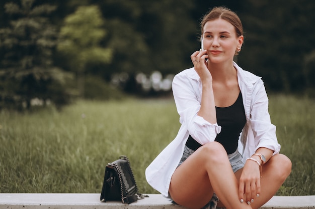 Free photo pretty girl sitting in the street and using phone