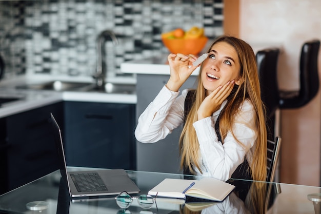 Free Photo pretty gorgeous woman use spray for eyes, feeling good after long laptop use, sitting at home