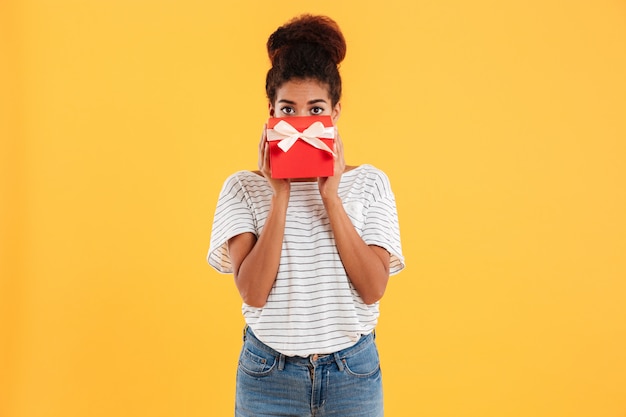 Pretty lady hiding face with present isolated