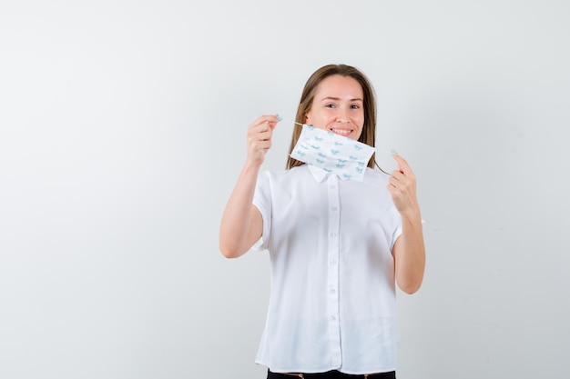 Pretty lady holding mask and looking cheerful