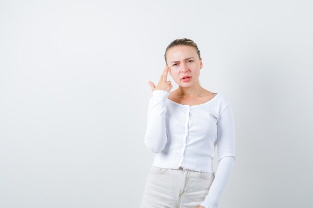 Pretty lady is shooting herself on white background