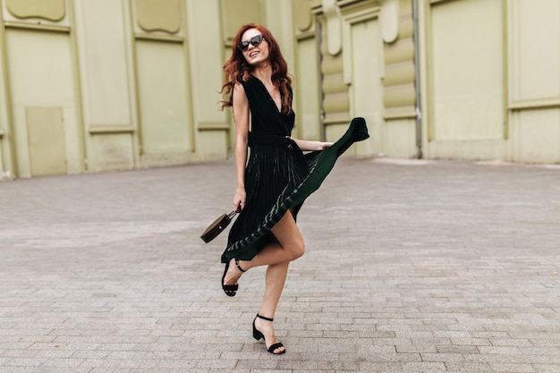 Free photo pretty lady in velvet dress posing outside