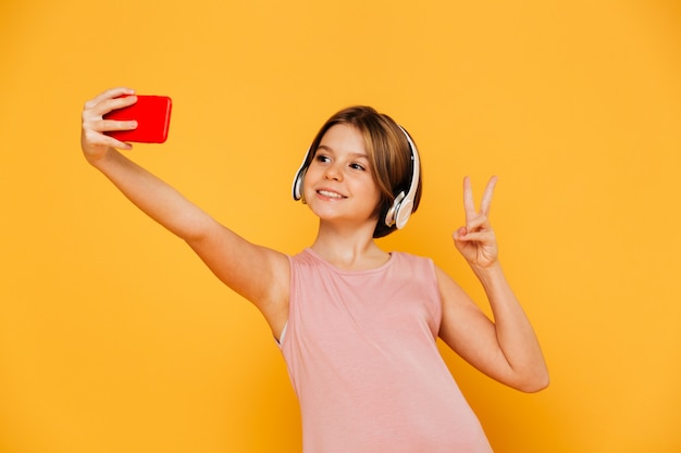 Pretty modern girl making selfie on smartphone isolated