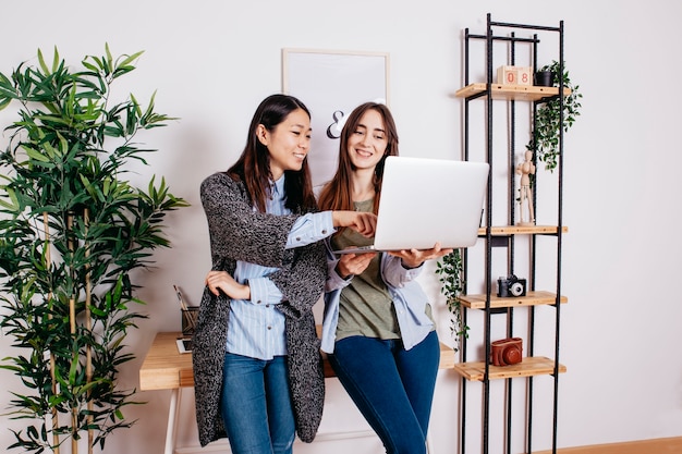 Pretty multiracial women coworking at laptop