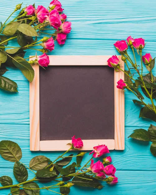 Pretty roses near chalkboard