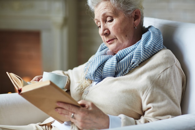 Free photo pretty senior woman reading book