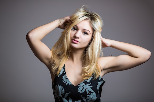 Pretty smiling good-looking beautiful woman isolated against blank studio wall.