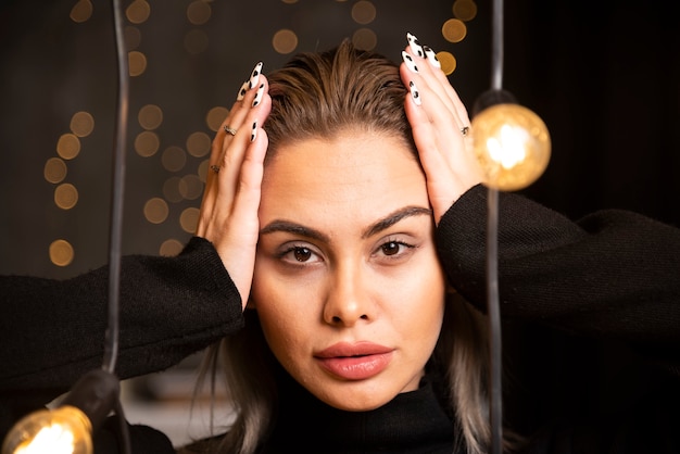 Pretty smiling woman dressed in black sweater and posing