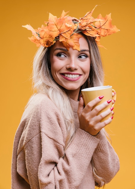 Free photo pretty smiling woman holding cup of coffee and looking away