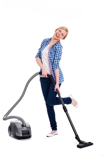 Pretty and smiling woman vacuuming a floor