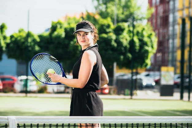 Pretty tennis player hitting ball on a sunny day