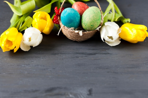 Free photo pretty tulips near basket with eggs