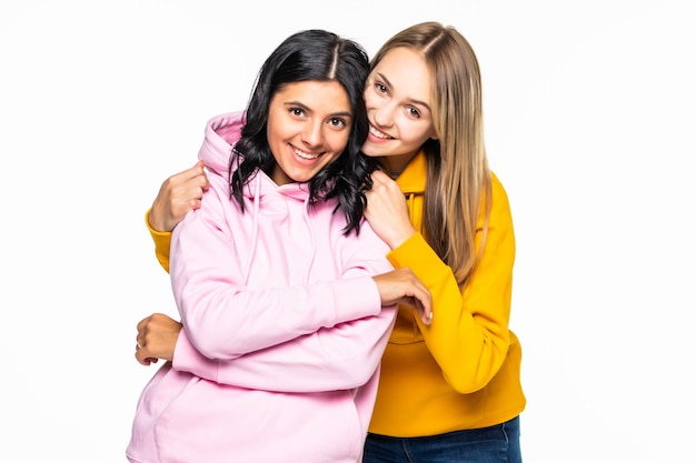 Free Photo pretty two women wearing in casual hoodies and jeans isolated white wall