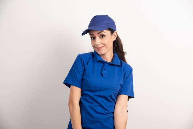 Pretty woman in blue uniform touch her face with hand. High quality photo