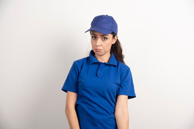 Pretty woman in blue uniform touch her face with hand. High quality photo