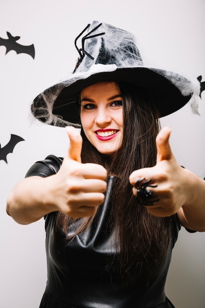 Free Photo pretty woman in decorated hat showing thumbs up