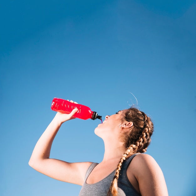 Free photo pretty woman drinking from bottle