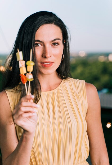 Pretty woman holding appetizers with blurred background