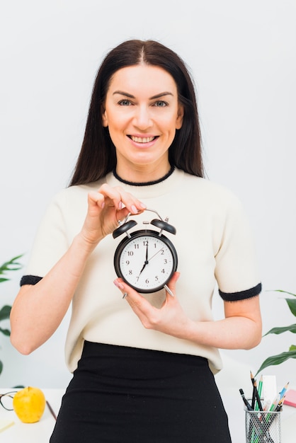 Pretty woman holding clock with 7 am