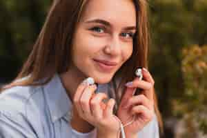 Free photo pretty woman holding earphones