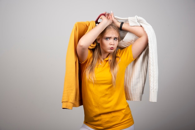 Free Photo a pretty woman holding hangers with clothes