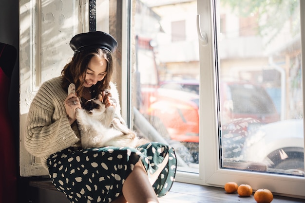 Free Photo pretty woman holding her cat paws stretching