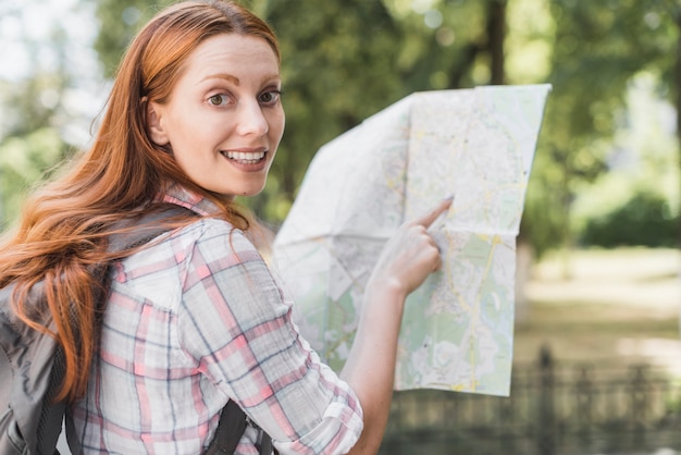 Free Photo pretty woman pointing in map