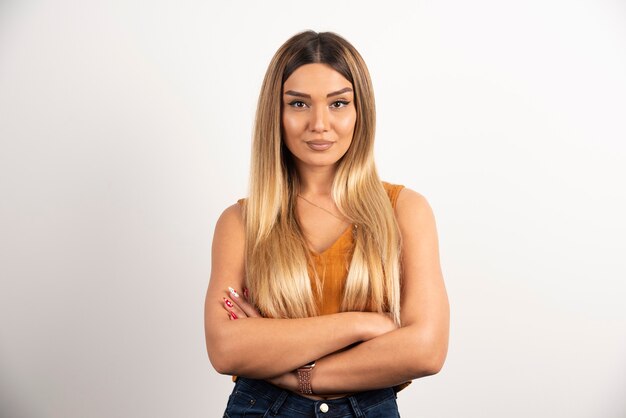 Pretty woman posing with crossed arms on white background.