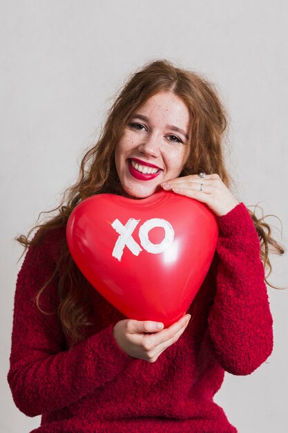 Pretty woman posing with a heart balloon