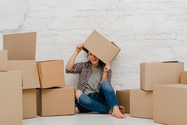 Free Photo pretty woman putting box on head