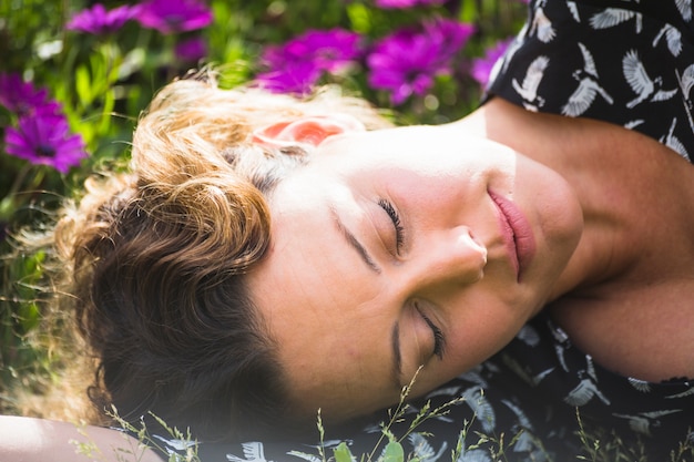 Free photo pretty woman sleeping in garden