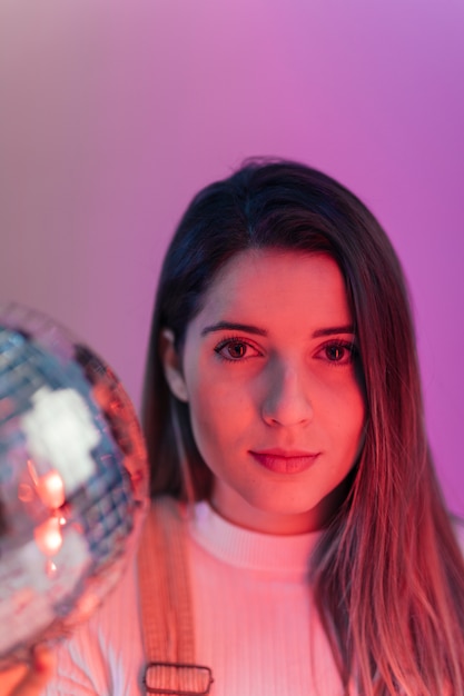 Free Photo pretty woman standing with disco ball