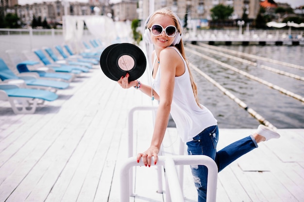 Free photo pretty woman standing with vinyl