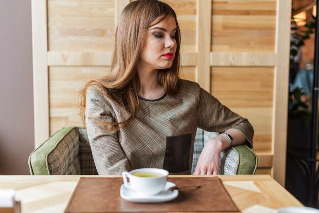 Pretty woman thinking while having tea