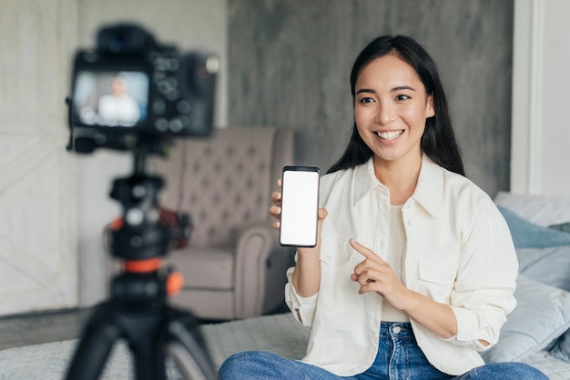 Pretty woman vlogging and pointing at her phone