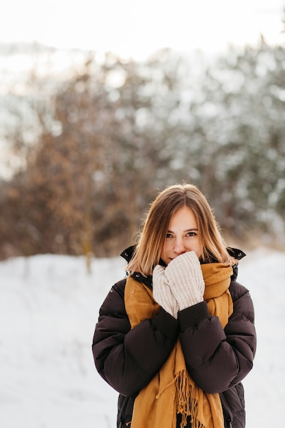 Free photo pretty woman in winter clothes warming hands