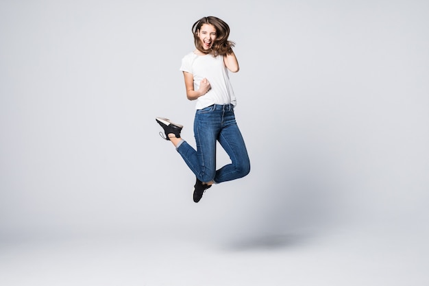 Free Photo pretty woman with brown long hair and happy smiling facial expression jumping up in studio isolated on white