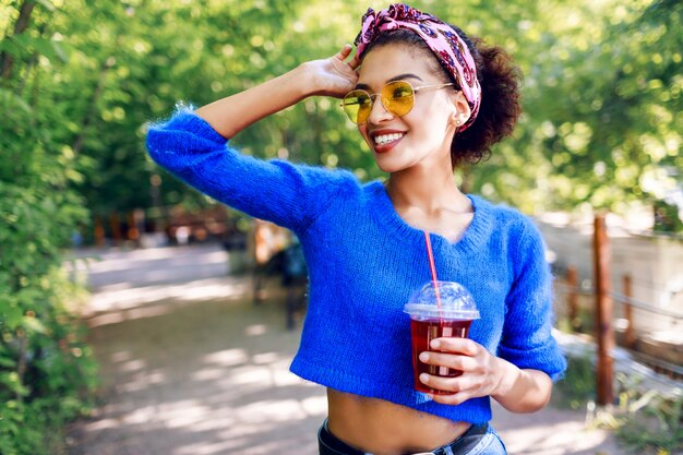 Pretty  woman with brown skin enjoying summer days in the park.