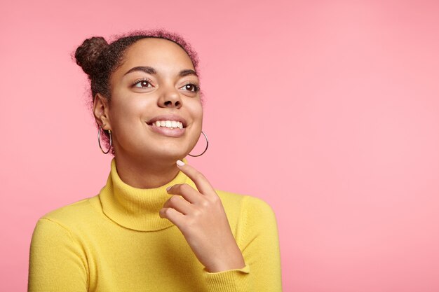 Pretty woman with space buns and yellow turtleneck