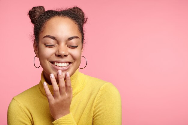 Pretty woman with space buns and yellow turtleneck