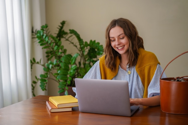 Pretty woman working at her home office, smiling end enjoying time at her living room.