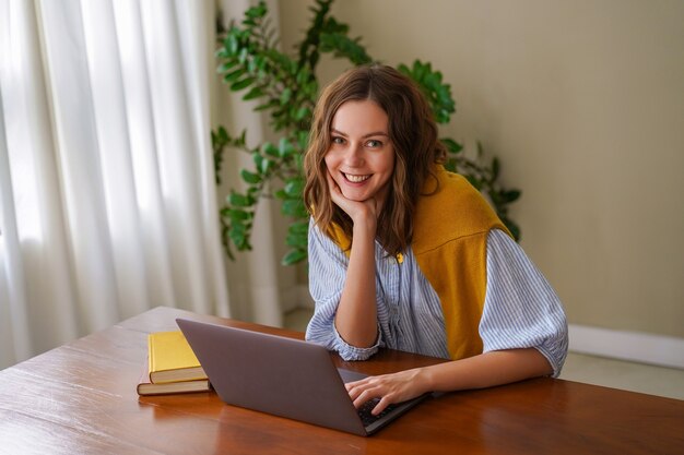 Pretty woman working at her home office, smiling end enjoying time at her living room.