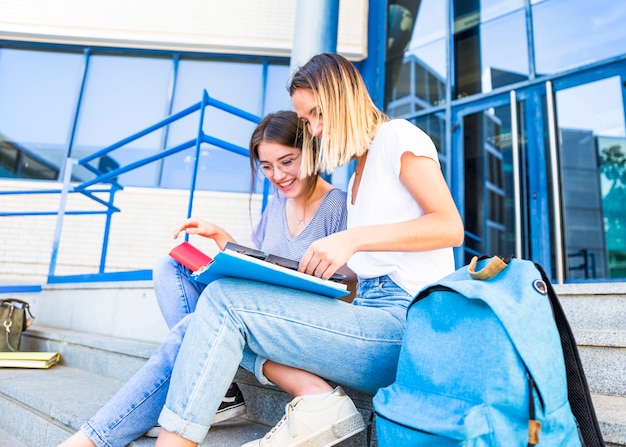 Free photo pretty women studying near university building