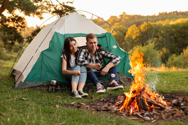 Pretty young couple enjoying bonfire