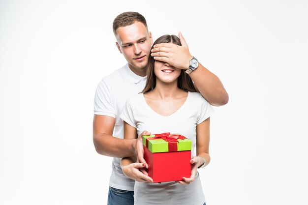 Pretty young couple man give his lady red giftbox surprise isolated on white