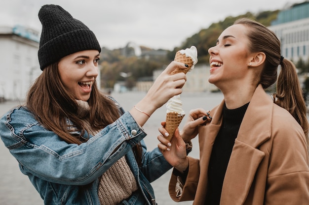 Free photo pretty young girl enjoying ice cream together