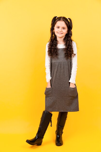 Pretty young girl posing with yellow background