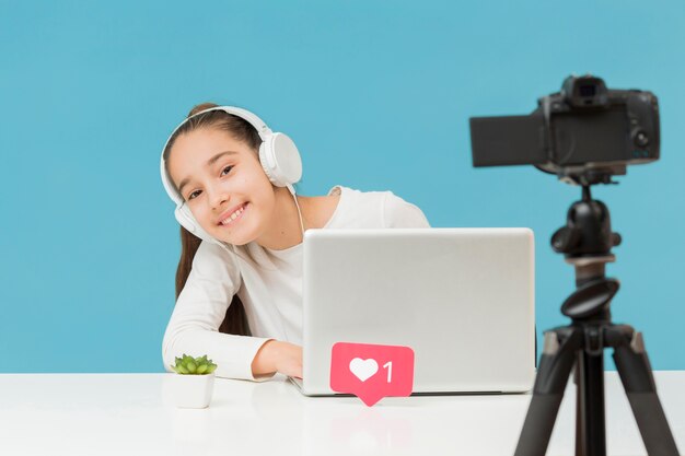 Pretty young girl recording herself at home